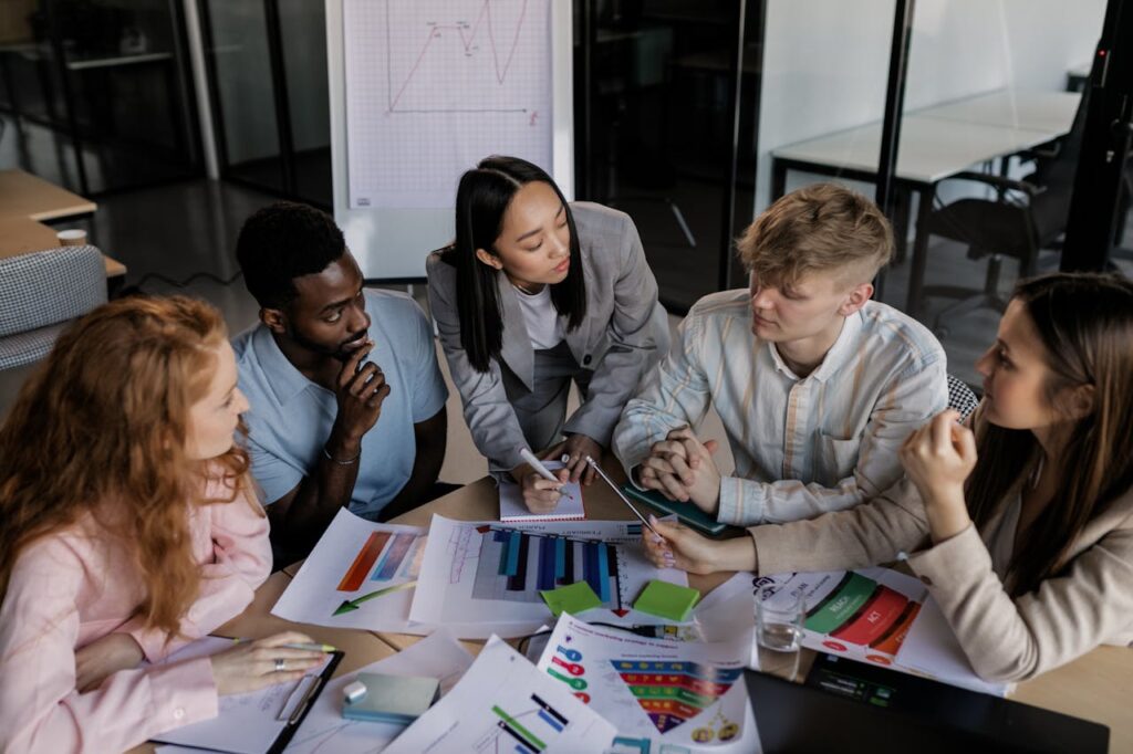 Diverse group of colleagues brainstorming and discussing strategy in a modern office setting.